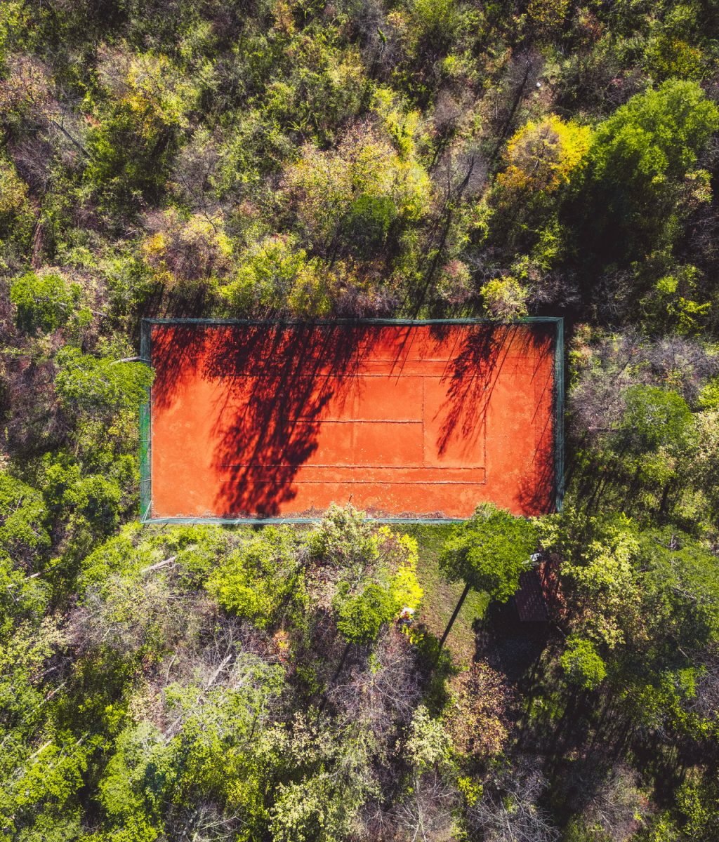 Orange sand on the tennis court top down view, tennis court in the forest
